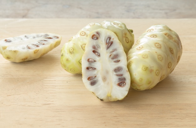 Noni of Morinda citrifolia, grote morinda, Indiase moerbei, strand moerbei of kaas fruit op houten tafel.