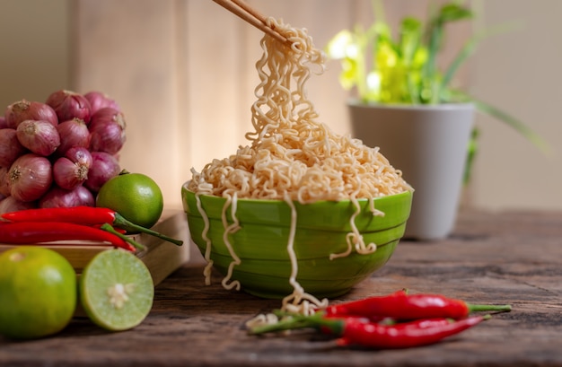 Noodle in a bowl with lime and chili and onion and vegetable