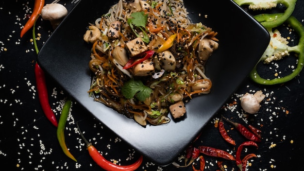 Noodle gebakken tofu en groentesalade op een bord. oosterse keuken eten. traditionele maaltijd.