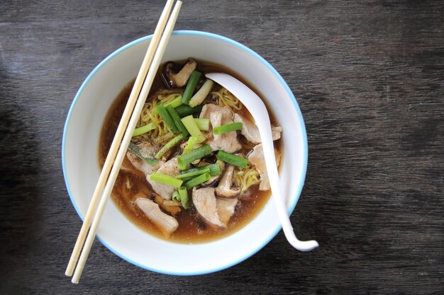 木の背景に豚肉と麺