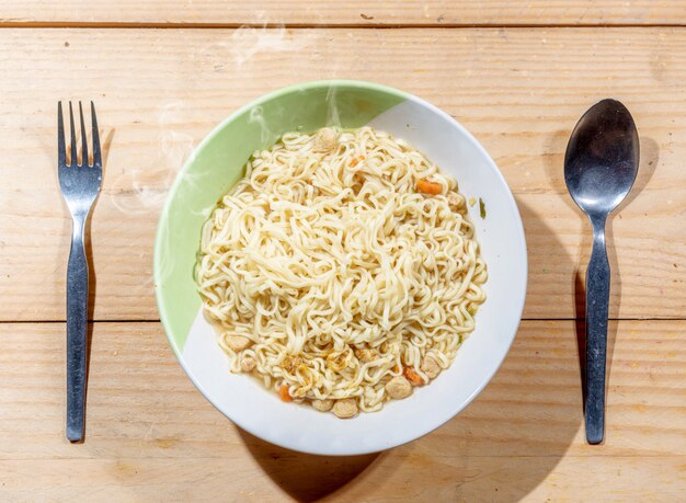 Noodles on the bowl with spoon and fork