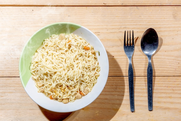 Noodles on the bowl with spoon and fork