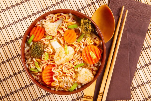 Noodles and vegetables arranged on bamboo mat representing the concept of Asian food