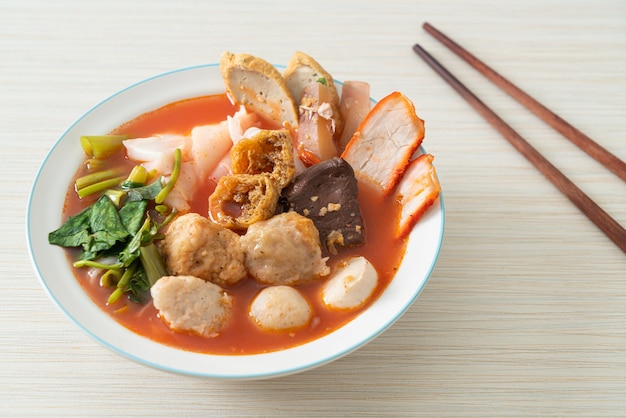 noodles with meatballs in pink soup or Yen Ta Four Noodles in Asian style