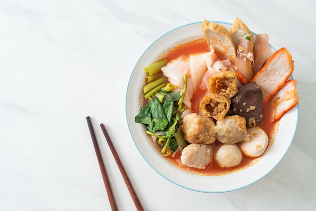 ピンクのスープにミートボールが入った麺