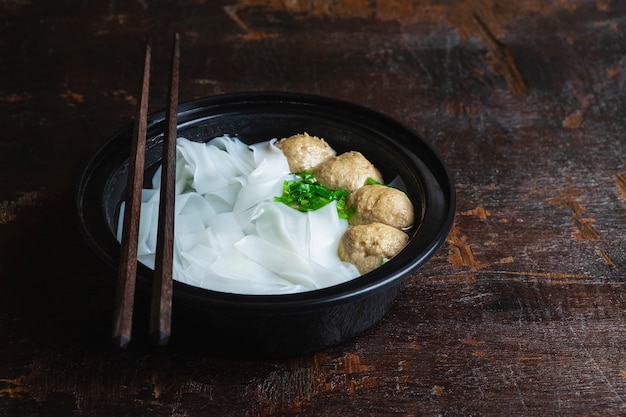 Noodles with meatballs on a wooden table