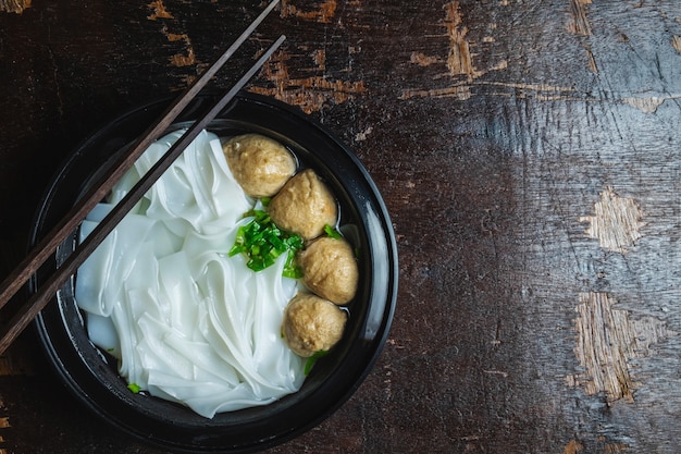 Noodles with meatballs on a wooden table