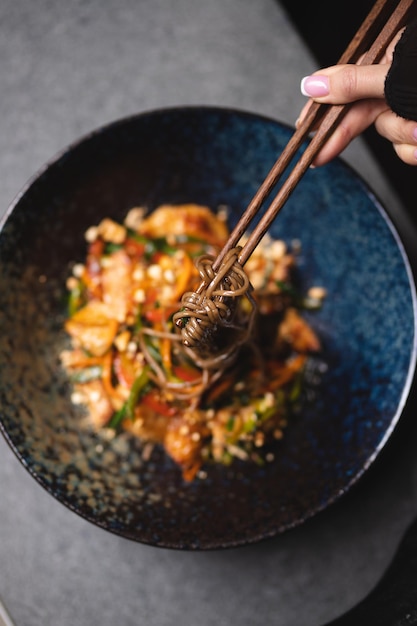 暗い背景に魚介類と野菜を入れた麺。アジア料理