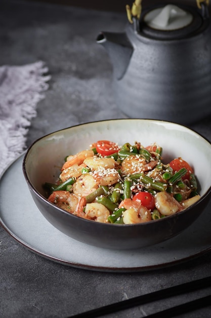 Noodles with shrimps and vegetables, Asian cuisine, Glass chinese noodles, Gray background, Selective focus