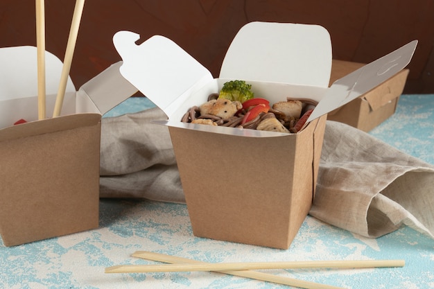 Noodles with vegetables and chicken in craft packaging