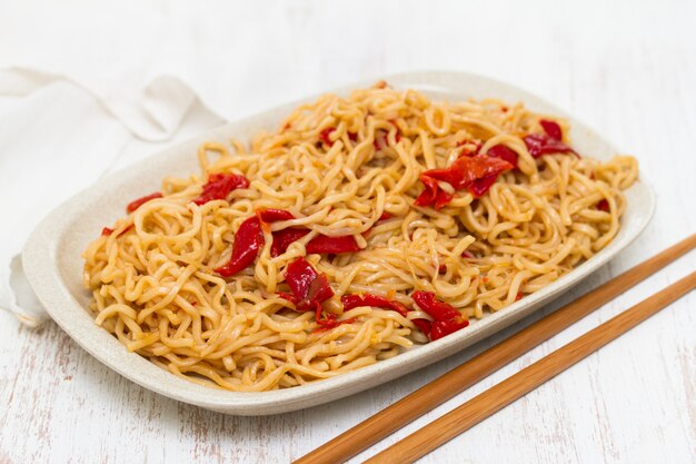 Noodles with vegetables on white dish