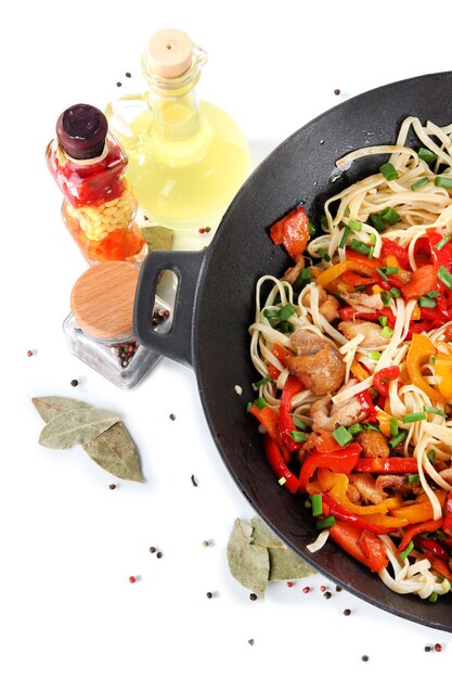 Noodles with vegetables on wok isolated on white