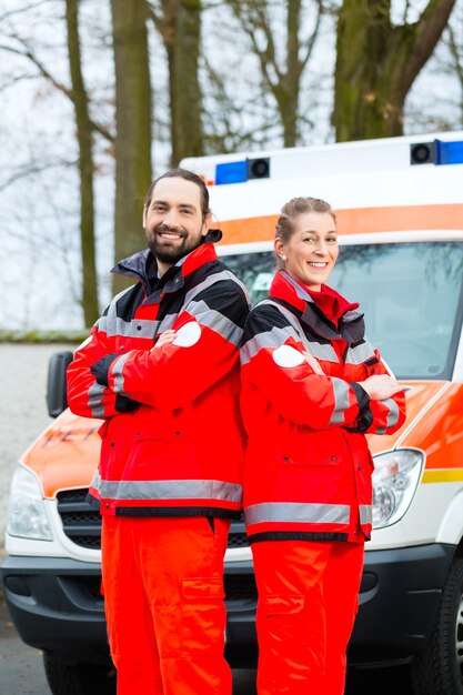 Foto noodsituatie arts en verpleegster die zich voor ambulanceauto bevinden