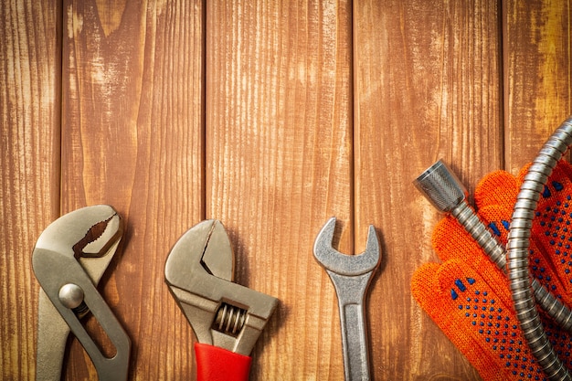 Noodzakelijke set gereedschappen voor loodgieters op een vintage houten houten achtergrond