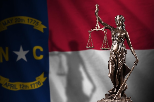 Noord-Carolina ons staat vlag met standbeeld van Vrouwe Justitia en gerechtelijke schalen in donkere kamer concept van