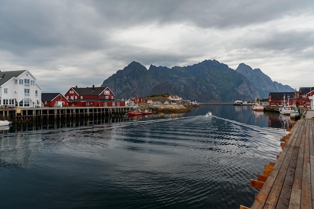 Noorse zeegezicht stadsgezicht van de stad henningsvaer een kleine boot beweegt tussen schiereilanden zeilen