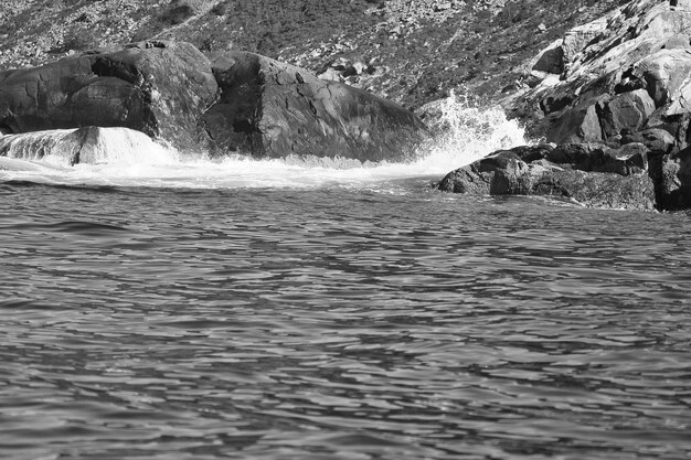 Noorwegen aan de fjord spray op rotsen in zwart-wit Waterspatten op rotsen