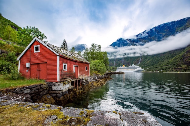 Noorwegen landschap, het huis aan de oever van de fjord op de achtergrond ligplaats cruiseschip.