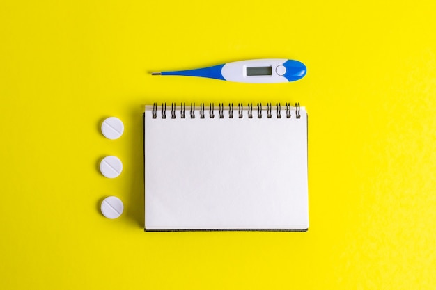 Nootebook with pills and thermometer