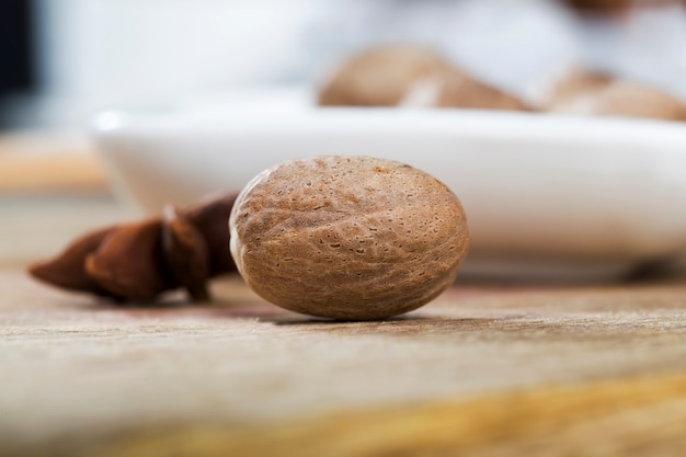 Nootmuskaat verspreid over een oude houten tafel in de keuken