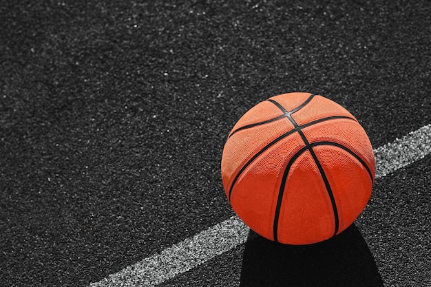 写真 地面に横たわっている孤立したオレンジ色のバスケットボールの人の写真