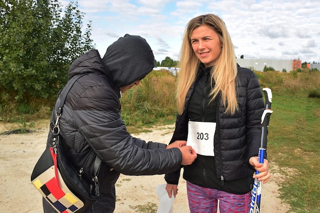 Nordic walking atleet blond meisje bereidt zich voor op de competitie en glimlacht