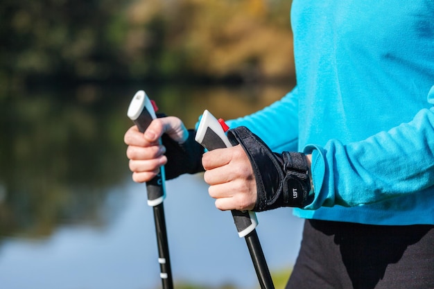 Nordic walking exercise adventure hiking concept closeup of woman's hand holding nordic walking poles