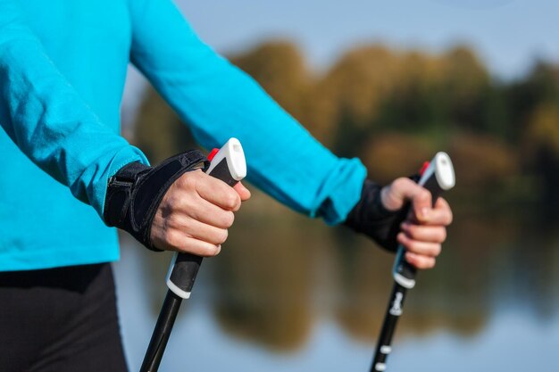 Nordic walking exercise adventure hiking concept closeup of woman's hand holding nordic walking poles