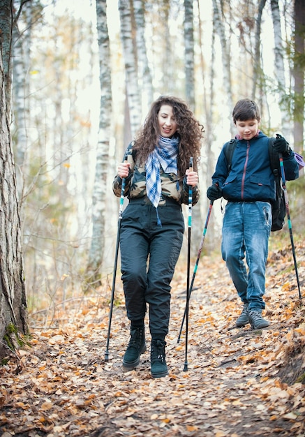 Nordic walking jonge vrouw en een kind dat naar de camera gaat