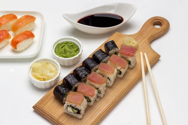 Nori maki sushi with salmon and tuna on cutting board