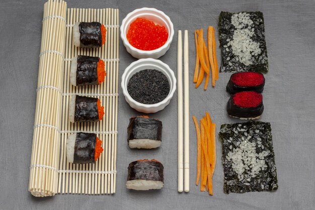 Nori sushi with caviar on bamboo mat and on table