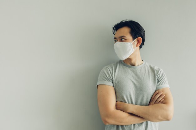 Normaal gezicht van de mens met witte hygiënische masker in grijs t-thirt met kopie ruimte.