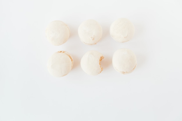 Normal and bitten marshmallows on white background