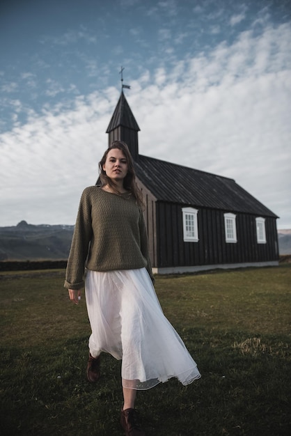Северные пейзажи Женщина созерцает одиночество церкви в Исландии