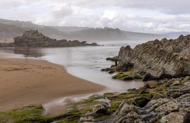 northern beach with waves and rocks under cloudy spring skies