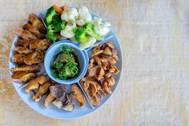 Photo northern thai green chilli dip served with streaky pork with crispy crackling and vegetables.