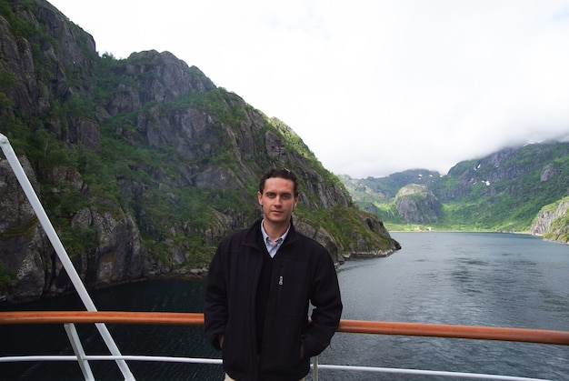Norway fjord mountain landscape with man tourist on cruise ship. Norway cruise vacation travel. Explore Norway. List of best parks and nature attractions. Journey through undisturbed nature.
