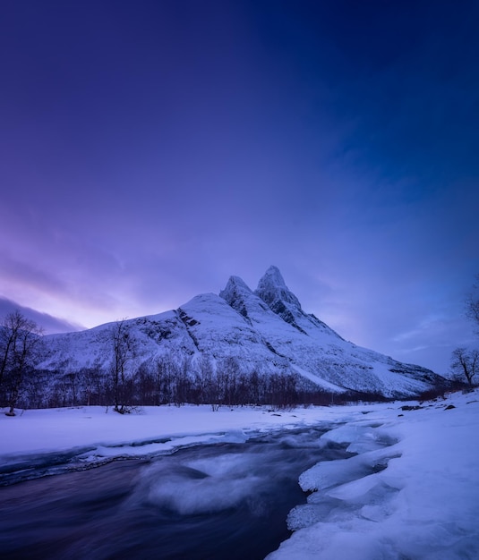 Norway frozen river and mountain a classic view in norway\
during winter cold weather and a snow storm landscape during\
sunset