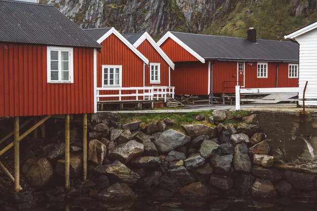 Foto norvegia rorbu case e montagne rocce sopra fiordo paesaggio scandinavo vista di viaggio lofoten