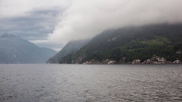 ノルウェー スカンジナビア 石造りの山の雨雲の湖岸の真ん中の美しい風景