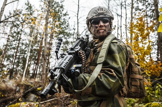 Norwegian Rapid reaction special forces FSK soldier patrolling in the forest. Field camo uniforms, combat helmet and eye-wear goggles are on