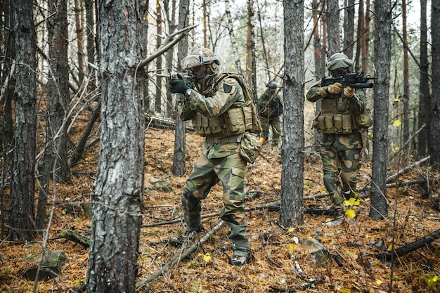 Norwegian Rapid reaction special forces FSK soldiers in field uniforms patrolling in the forest trees