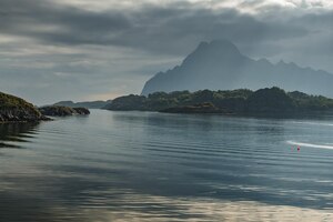 Photo norwegian seascape, rocky coast with dramatic skies, the sun breaks through the clouds, sheer cliffs, small islands illuminated by the sun. high quality photo