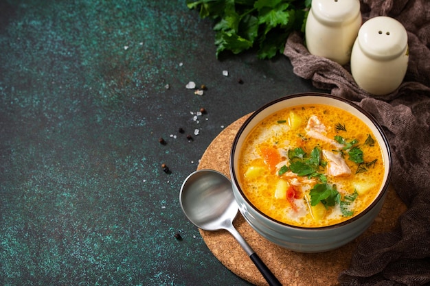 Norwegian soup with cream and salmon on a dark stone background Copy space