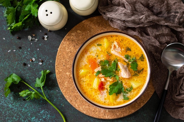 Norwegian soup with cream and salmon on a dark stone background Top view flat lay background