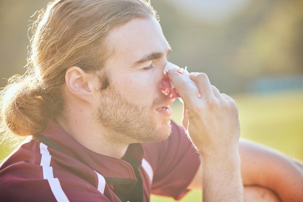 写真 緊急健康事故と屋外の血液を伴うフィールド上の鼻血男性のクローズアップとスポーツ傷害のクローズアップ試合や運動後の医療と痛みや打撲傷を伴う腫れた壊れた男性アスリート