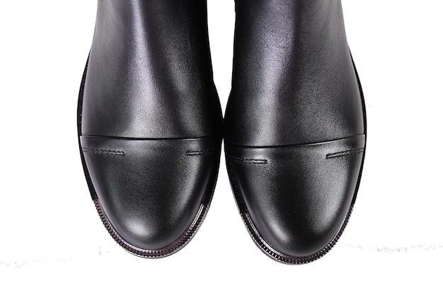Носы перед черными женскими сапогами крупным планом на белом фоне Женские туфли на высоком каблуке