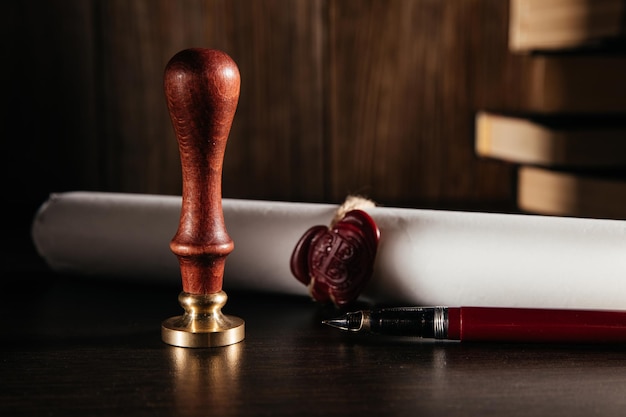 Notary's public pen and document with wax stamp at wooden desk closeup