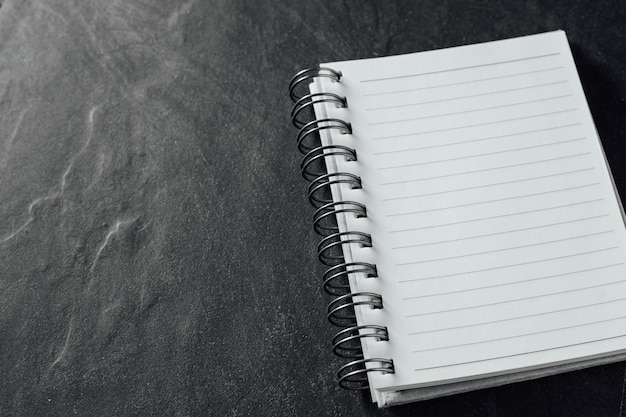 the note book on black stone background