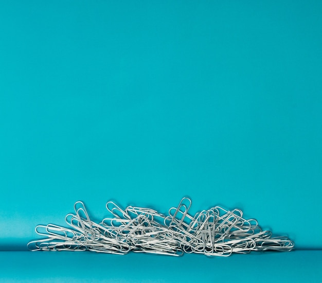 Note paper clips on blue background with copyspace